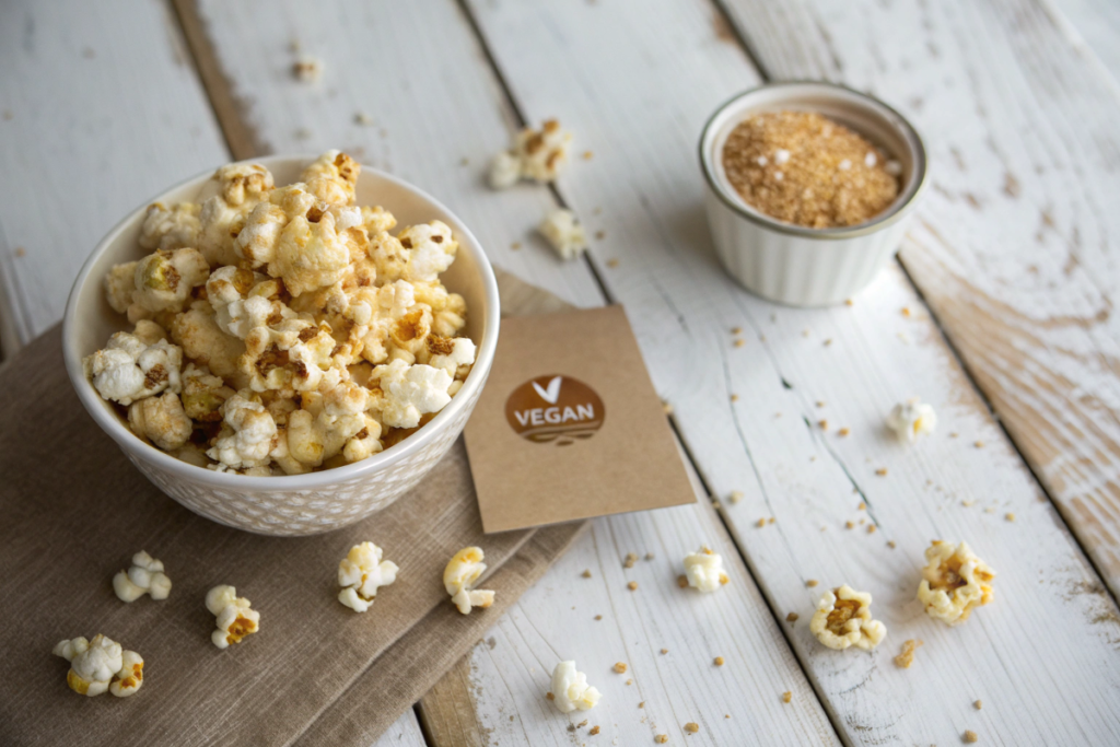 Bowl of freshly popped vegan popcorn with a sprinkle of salt, emphasizing its plant-based simplicity.